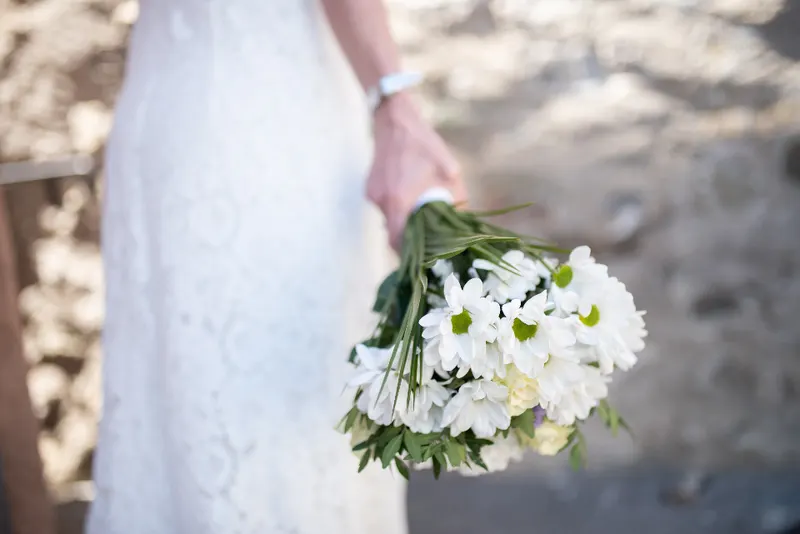 La novia sostiene un ramo de margaritas blancas