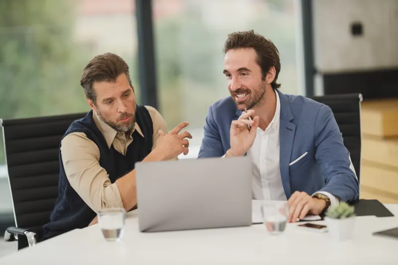 Dos integrantes del equipo revisan un prototipo en una laptop